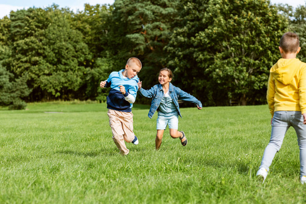 happy children playing and running at park - Fotoğraf, Görsel