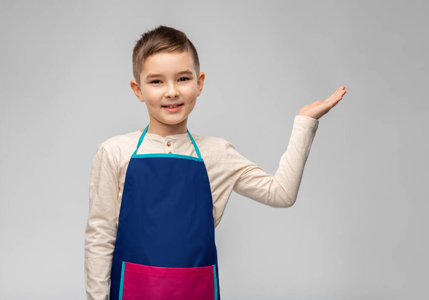 little boy in apron holding something on hand - Foto, Imagem