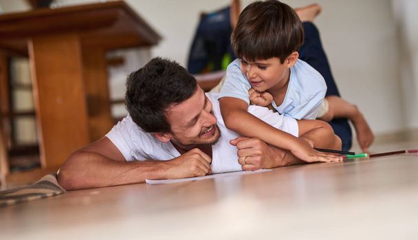 Проводити деякий час зі своїм сином. Повнометражний знімок батька, який грає з сином на підлозі вдома
. - Фото, зображення