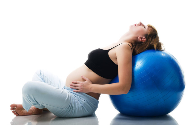 zwangere vrouw beoefenen van yoga met bal - Foto, afbeelding
