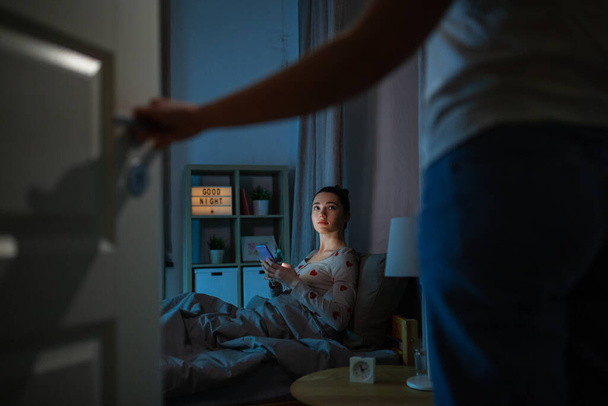 teenage girl with tablet pc in bed at night - 写真・画像