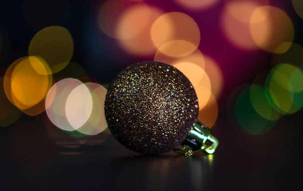 Χριστουγεννιάτικη διακόσμηση και στολίδια. Χριστουγεννιάτικη σύνθεση σε θολά φώτα φόντο. Λαμπερή Χριστουγεννιάτικη μπάλα. - Φωτογραφία, εικόνα