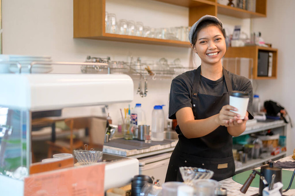 Young service minded barista woman working in coffee shop - Foto, imagen