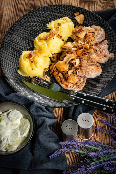 Grilled pork loin with onion and champignons, served with mashed potatoes. - Φωτογραφία, εικόνα