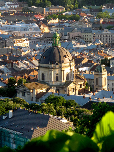 Top kilátás a tető egy régi európai város - Lviv. Régi építészet, régi, rozsdás tetők, kilátás a városra a városházáról naplementekor. Kilátás egy régi európai városra magasról  - Fotó, kép