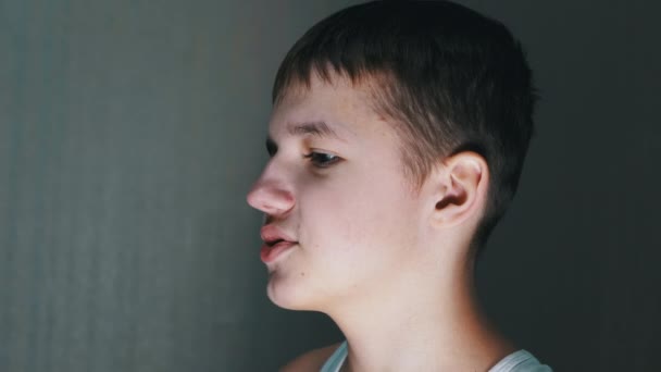 Close-up van een gezichtsprofiel van pratende tiener die naar beneden kijkt. Zijaanzicht - Video