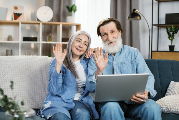 Happy mature couple Using Laptop Watching Movie Together Sitting On Couch At Home. - Photo, Image