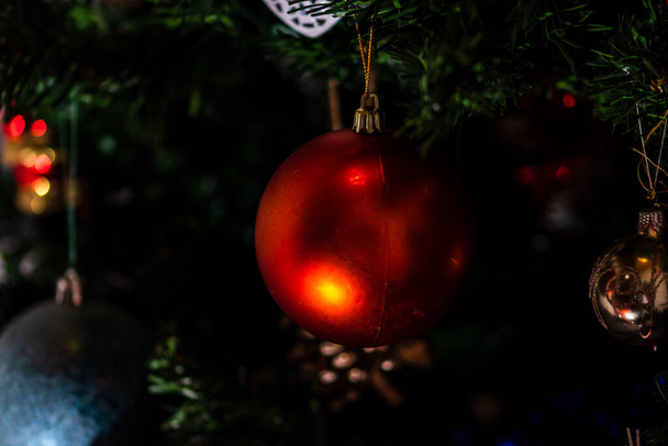 Рождественские украшения на елке. Украшенная елка. Ветка ели с рождественскими безделушками. - Фото, изображение