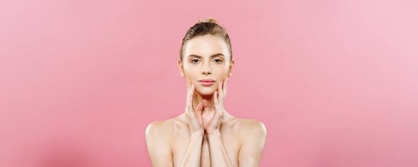 Beauty Spa Concept - Caucasian Woman with perfect face skin Portrait. Beautiful Brunette Spa Girl showing empty copy space. Isolated on pink studio background. Proposing a product. - Valokuva, kuva