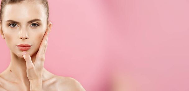 Schönheitskonzept - Nahaufnahme Porträt von attraktiven kaukasischen Mädchen mit Schönheit natürliche Haut isoliert auf rosa Hintergrund mit Kopierraum. - Foto, Bild