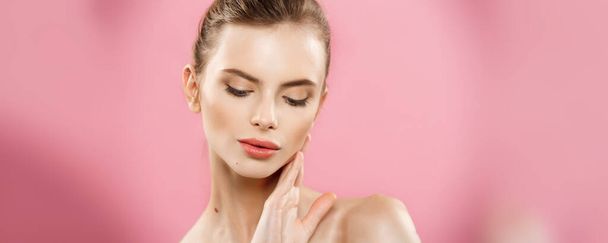 Ομορφιά δέρμα Concept - όμορφη νεαρή γυναίκα Καυκάσιος με καθαρό νωπό δέρμα φαίνονται μακριά με φόντο ροζ studio. Κορίτσι ομορφιά περιποίηση προσώπου. Θεραπεία προσώπου. Κοσμετολογία, ομορφιάς και ευεξίας. - Φωτογραφία, εικόνα