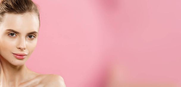 Schönheitskonzept - Nahaufnahme Porträt von attraktiven kaukasischen Mädchen mit Schönheit natürliche Haut isoliert auf rosa Hintergrund mit Kopierraum. - Foto, Bild