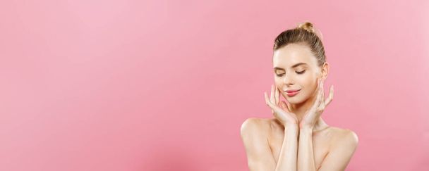 Beauty Concept - mooie vrouw met schone frisse huid close-up op roze studio. Gezicht van de zorg van de huid. Cosmetologie. - Foto, afbeelding
