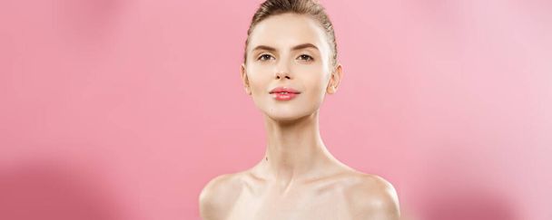 Beauty Spa Concept - Кавказька жінка з ідеальною шкірою обличчя Портрет. Красива брюнетка Спа-дівчина, що показує порожнє місце для копіювання. Ізольовані на рожевому студійному фоні. Пропозиція продукту
. - Фото, зображення