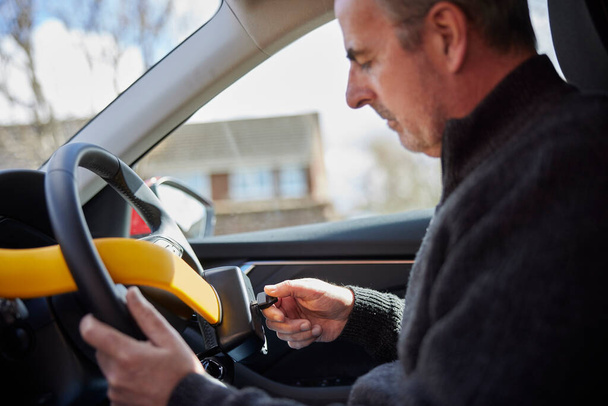Mature Man Fitting Manual Steering Wheel Lock In Car - Φωτογραφία, εικόνα
