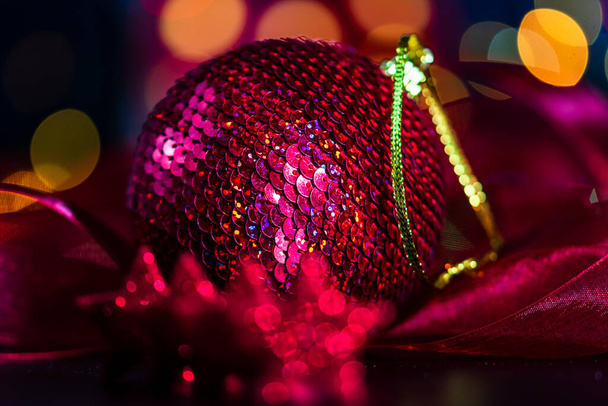 Διακόσμηση και στολίδια σε μια πολύχρωμη χριστουγεννιάτικη σύνθεση που απομονώνονται σε φόντο θολή φώτα. - Φωτογραφία, εικόνα