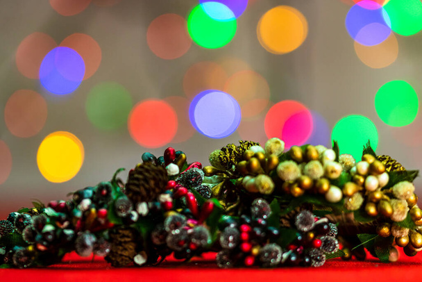 Bulanık ışıkların arka planında izole edilmiş renkli Noel çelenkleri. - Fotoğraf, Görsel