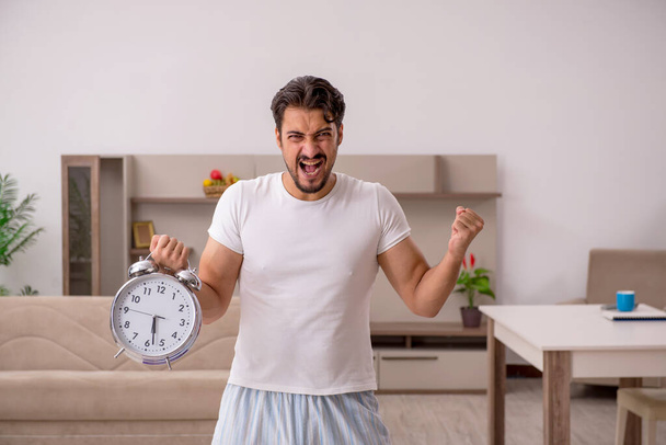 Young man doing sport exercises at home in time management conce - Photo, Image