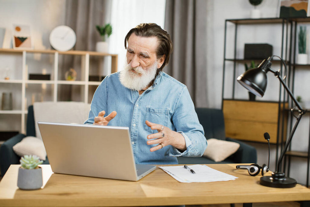 Smiling mature businessman using modern laptop for video chat at remote work. - 写真・画像