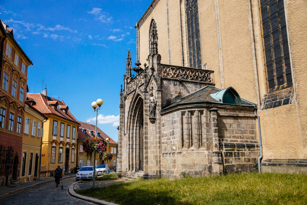 Cheb, Czechy Zachodnie, Czechy, 14 sierpnia 2021 r.: gotycki średniowieczny kościół św. Mikołaja i św. Elżbiety z dzwonnicami, stare miasto Eger w słoneczny letni dzień, łukowy kamienny portal - Zdjęcie, obraz