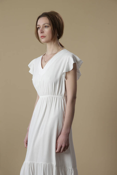 Uzun beyaz yaz elbisesi giymiş bir kadının stüdyo fotoğrafı.. - Fotoğraf, Görsel
