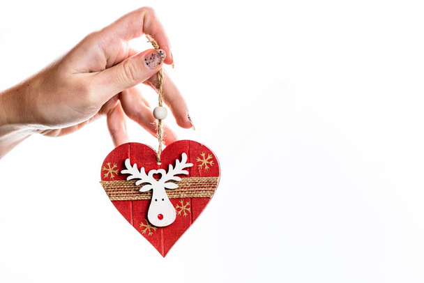 El ele tutuşan kalp şeklindeki Noel süslemesi beyaza izole edilmiş.. - Fotoğraf, Görsel