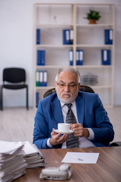 Old male employee drinking coffee during break - Zdjęcie, obraz