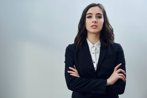 portrait of a beautiful young businesswoman wearing black jacket on a white background - Фото, изображение
