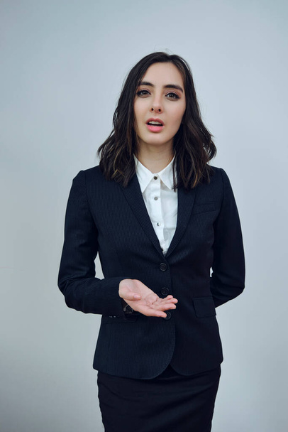 portrait of a beautiful young businesswoman wearing black jacket on a white background - Fotó, kép