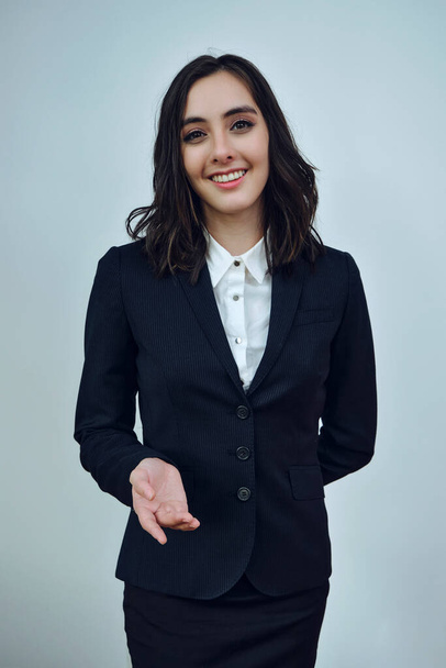 πορτρέτο μιας χαμογελαστής νεαρής επιχειρηματία που φοράει μαύρο μπουφάν σε λευκό φόντο - Φωτογραφία, εικόνα