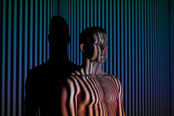 Into the mind of the man. Studio shot of a young man posing against abstract lighting. - Zdjęcie, obraz