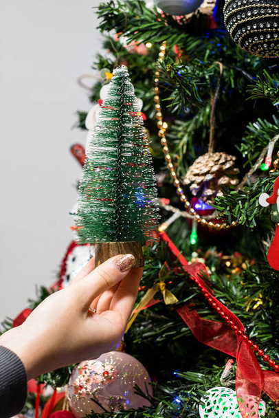 Het ophangen van kerstversieringen en ornamenten in de kerstboom - Foto, afbeelding
