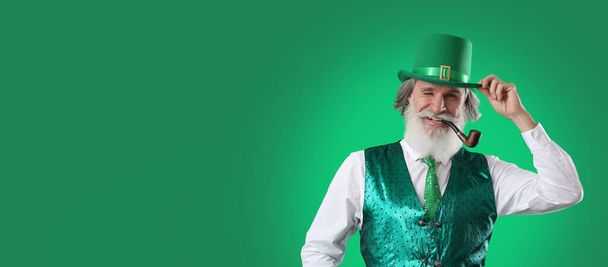 Старший мужчина курит трубку на зеленом фоне с пространством для текста. Празднование Дня Святого Патрика - Фото, изображение