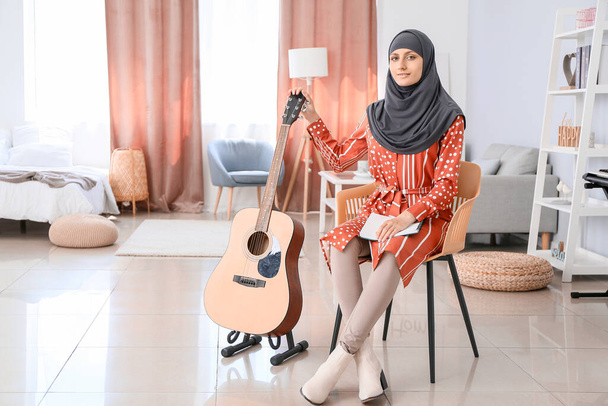 Moslim muziekleraar met gitaar thuis - Foto, afbeelding
