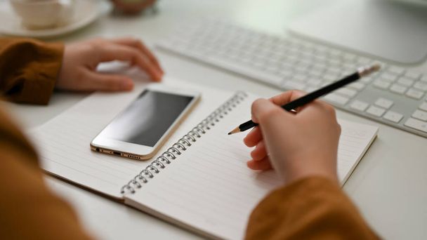 Close-up hands, Female college student doing her homework at her desk, writing on school notebook. - Φωτογραφία, εικόνα