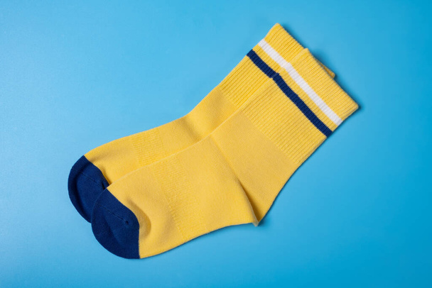 Pari keltaisia sukkia pojalle sinisellä pohjalla - Valokuva, kuva