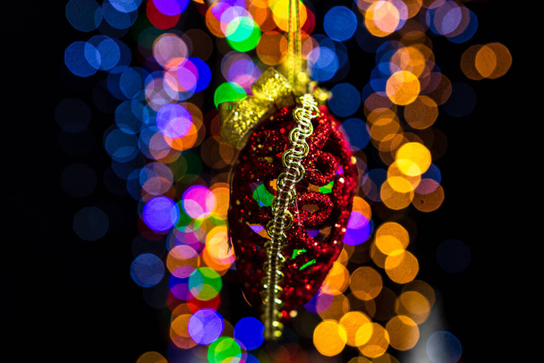 Holding Christmas decoration against bokeh lights background - Photo, Image