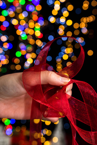 Holding Christmas decoration against bokeh lights background - Fotografie, Obrázek