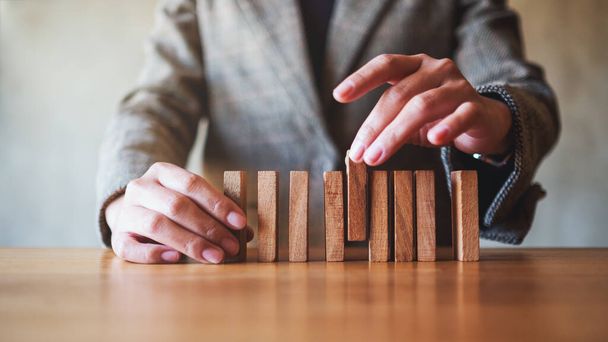 Closeup image of businessman putting wooden block in a row on the table for business concept - Foto, imagen