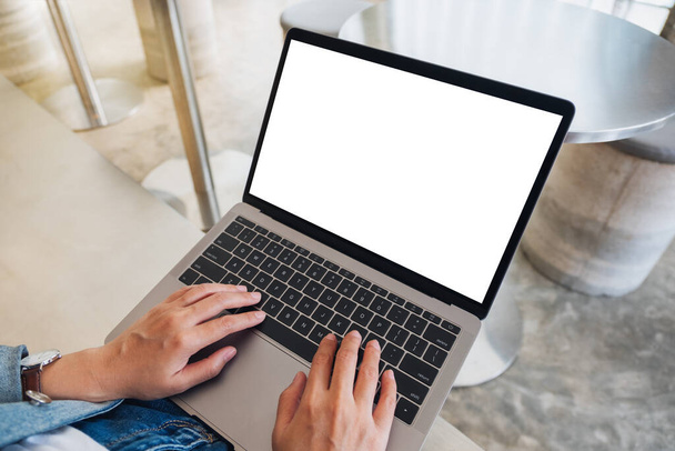 Visualizzazione dall'alto immagine mockup di una donna che utilizza e digita sul computer portatile con schermo desktop bianco vuoto  - Foto, immagini