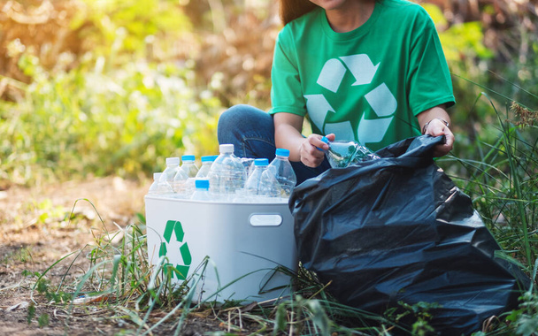 Nainen poimien roskat muovipullot laatikkoon ja muovipussiin kierrätykseen käsite - Valokuva, kuva