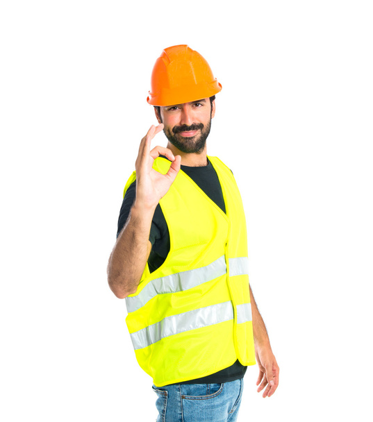 Workman making Ok sign over white background - Foto, afbeelding