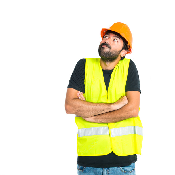 workman met zijn armen overgestoken op witte achtergrond - Foto, afbeelding