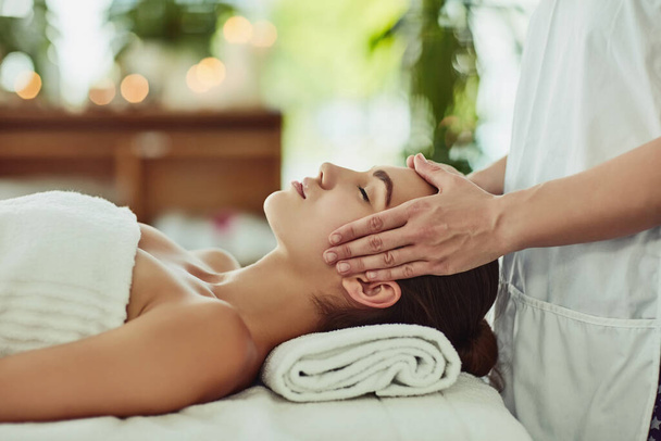 Give yourself the gift of relaxation. Shot of an attractive young woman getting massaged at a beauty spa. - Foto, Imagen