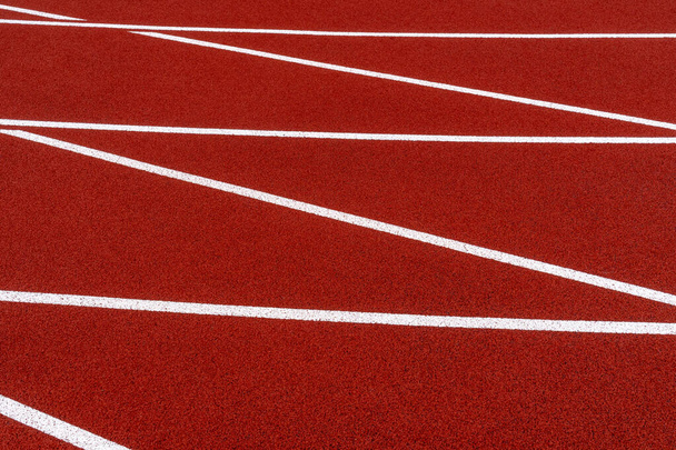 Red running track field at stadium with white lines  - Foto, imagen