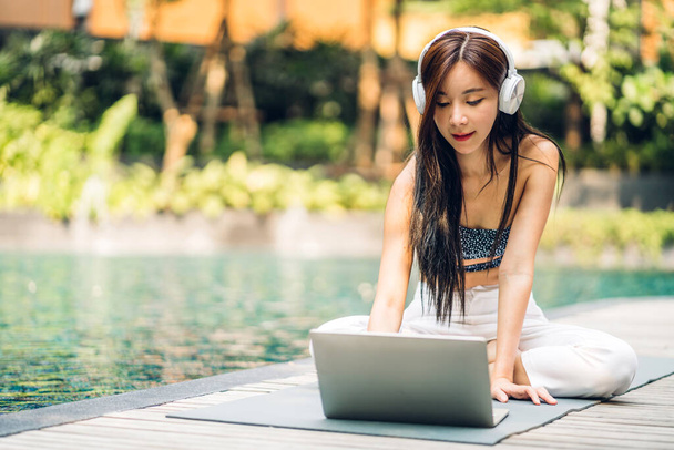 Portret uśmiechniętej szczęśliwej urody azjatycki freelancer podróżnik blogger kobieta relaks przy użyciu i technologii pracy laptopa w basenie na letnie wakacje podróży relaks w ośrodku spa - Zdjęcie, obraz