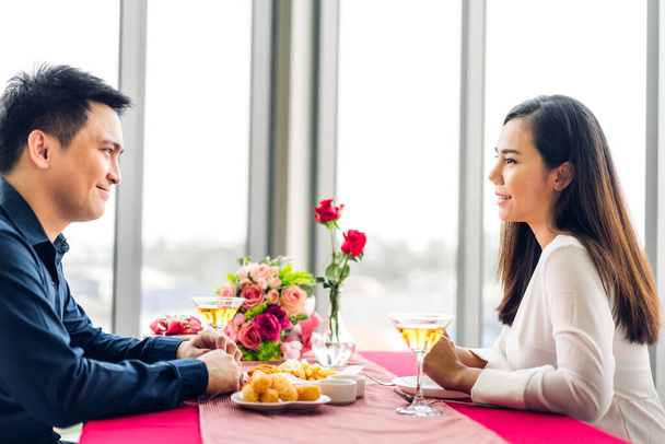 romantique jeune asiatique heureux amour couple relaxant et parler ensemble boire verres à vin célébrer à dîner partie couché sur chaise dans le restaurant.date et anniversaire concept - Photo, image