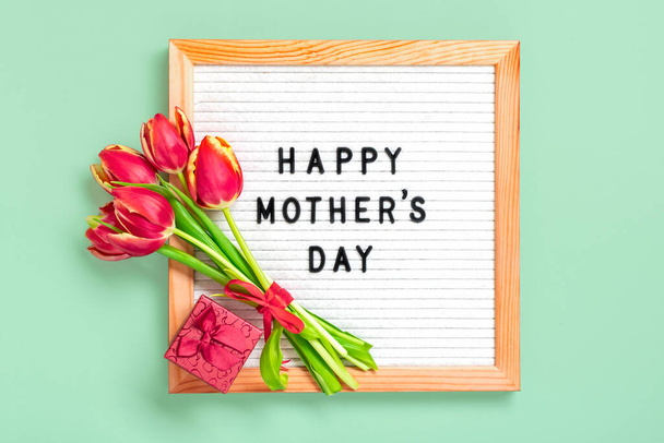 Plstěná deska s textem Šťastný Den matek, červené tulipány kytice na zeleném pozadí pozdrav dovolená karta Flat lay Top view - Fotografie, Obrázek