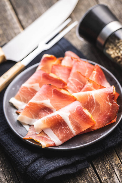 Sliced schwarzwald ham. Dried prosciutto ham on a plate. - Fotó, kép