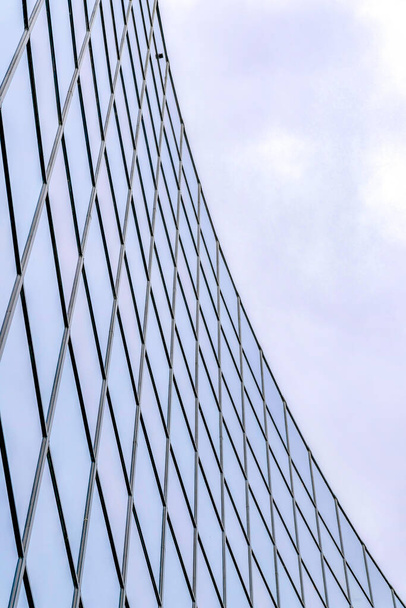 Edifício de vidro em uma visão de baixo ângulo no Vale do Silício, área da baía de San Jose, Califórnia. Edifício exterior com paredes de vidro reflexivo contra as nuvens escuras no céu. - Foto, Imagem